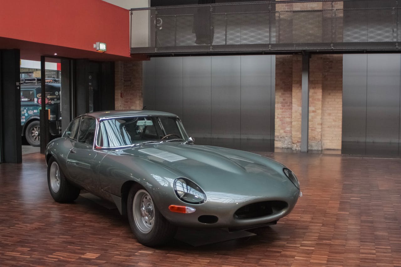 Classic Jaguar E-Type sports car exhibited indoors, showcasing luxury and vintage design.